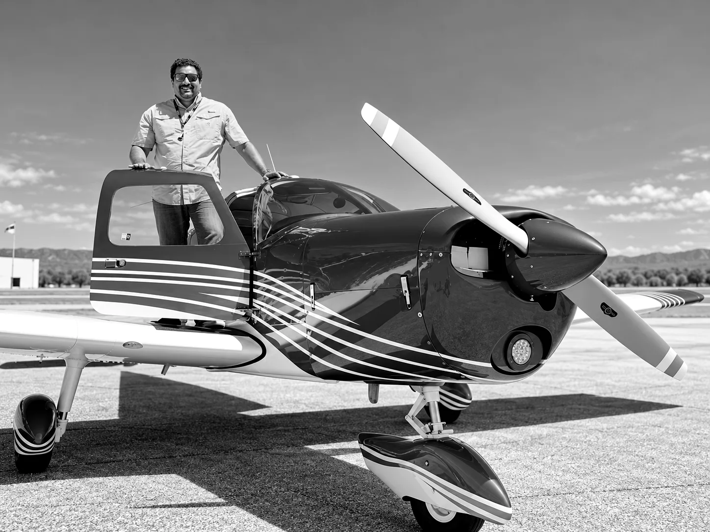Dan Guzmán, co-founder of Transekur, standing on the wing of a light aircraft.