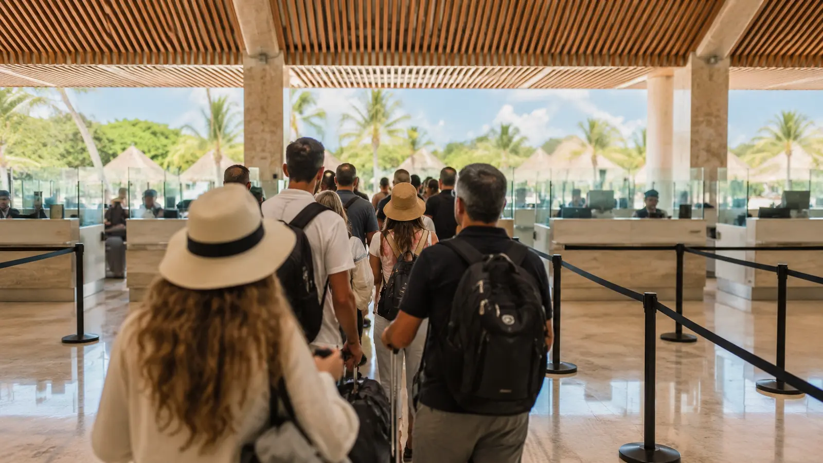Travelers queueing at immigration counters in a busy Caribbean airport arrivals hall