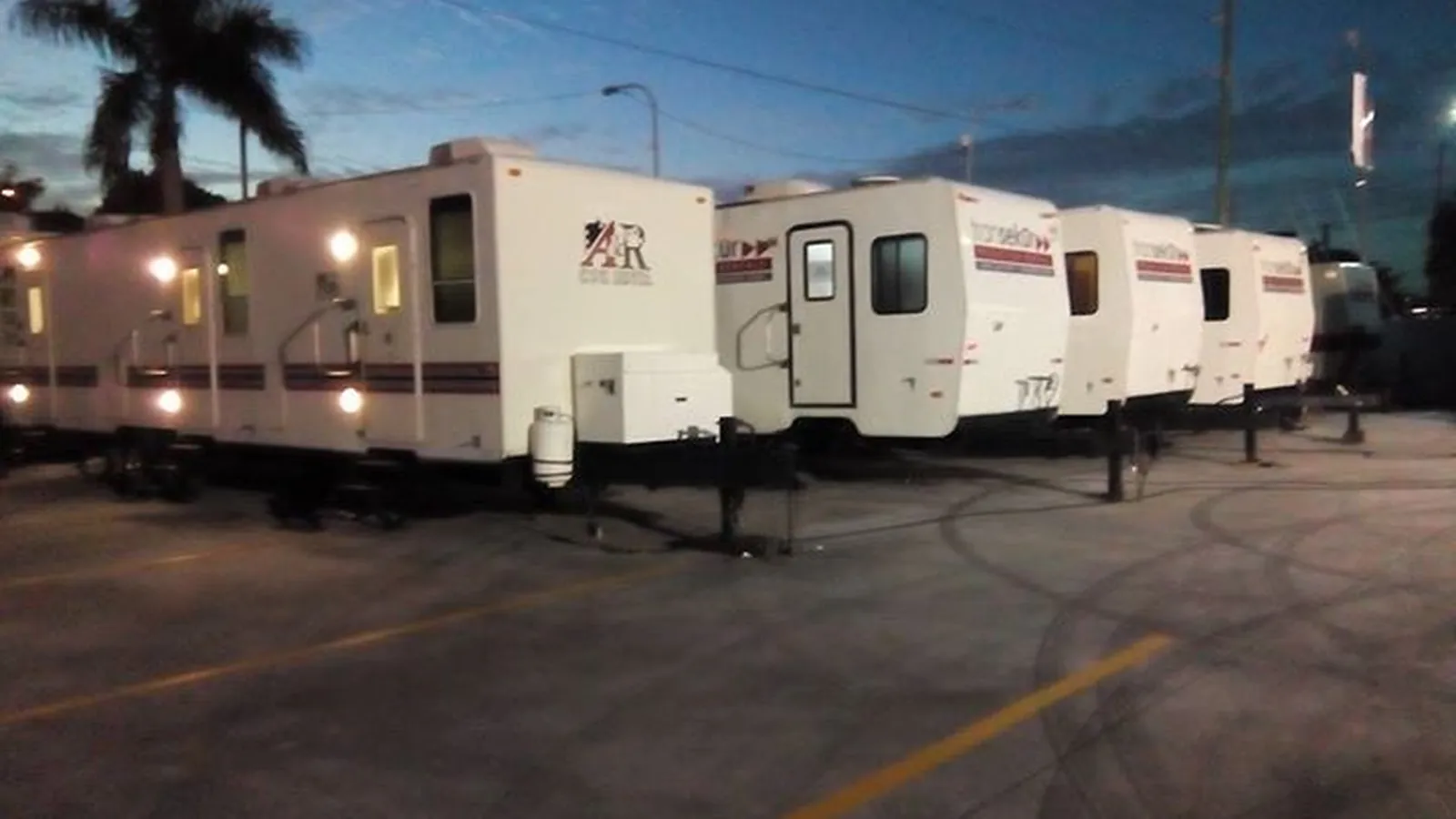 Remorques de production Transekur alignées sur un camp de base au crépuscule