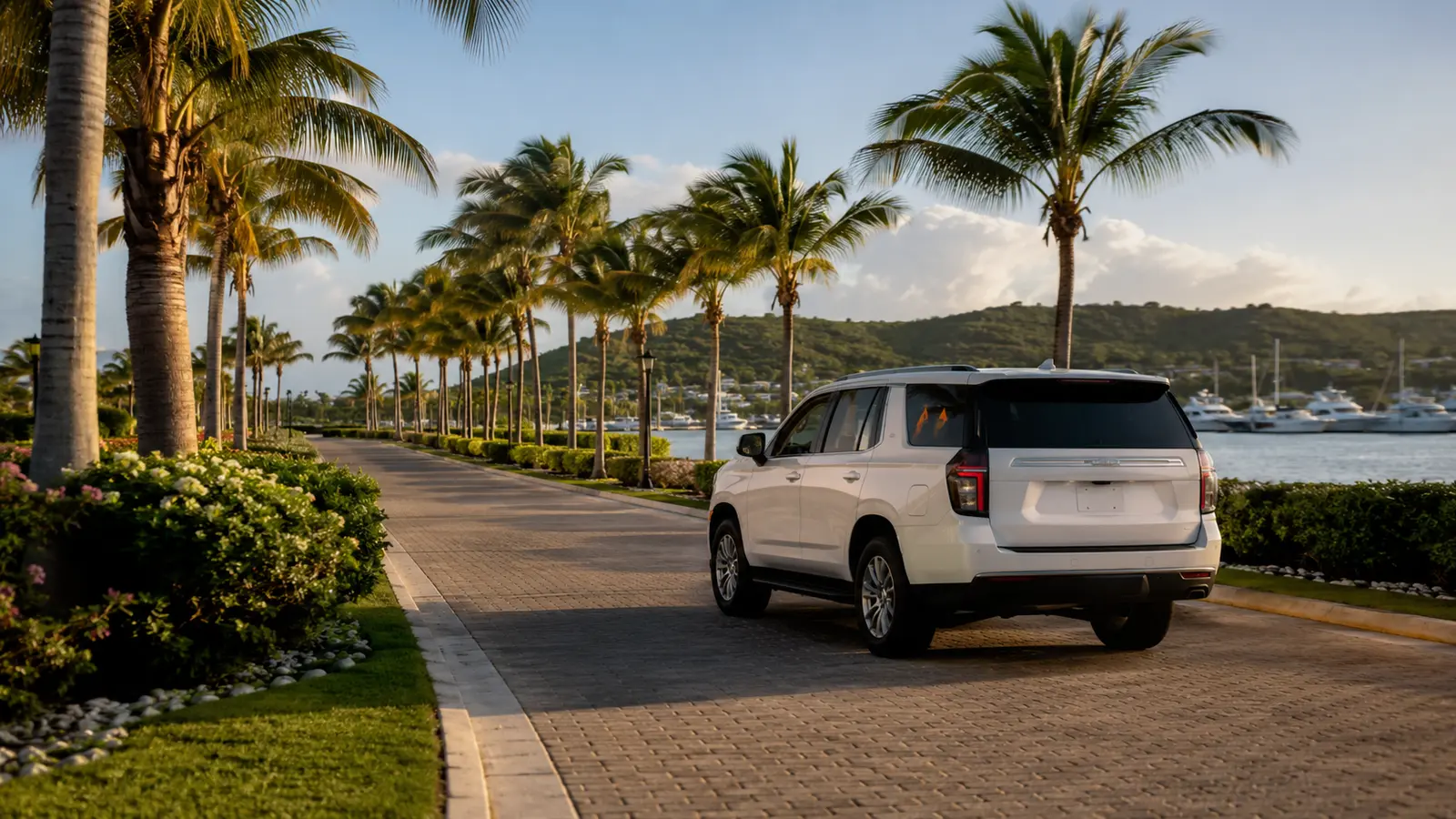 Travelers boarding a black chauffeured van at a lit resort arrival portico in Bávaro at dusk
